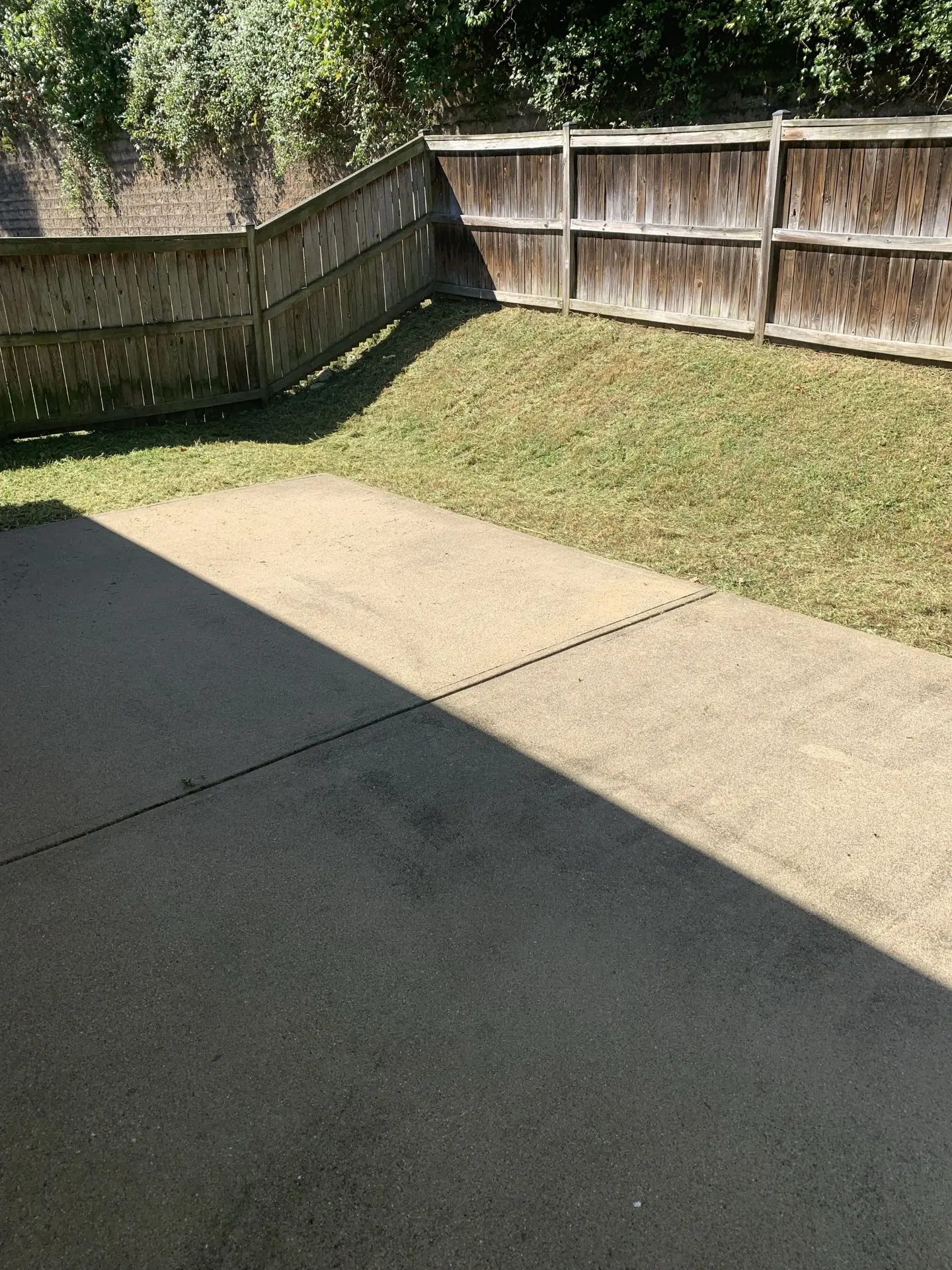 Cleanly cut grass slope beside a swept concrete driveway
